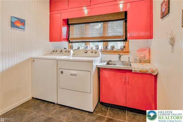 laundry area with washing machine and clothes dryer, cabinet space, and baseboards