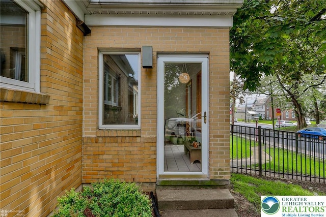 property entrance featuring brick siding