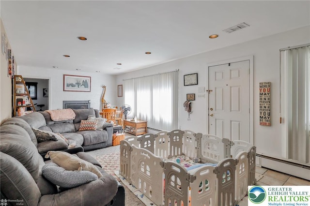 living room with baseboard heating, light tile patterned flooring, and recessed lighting