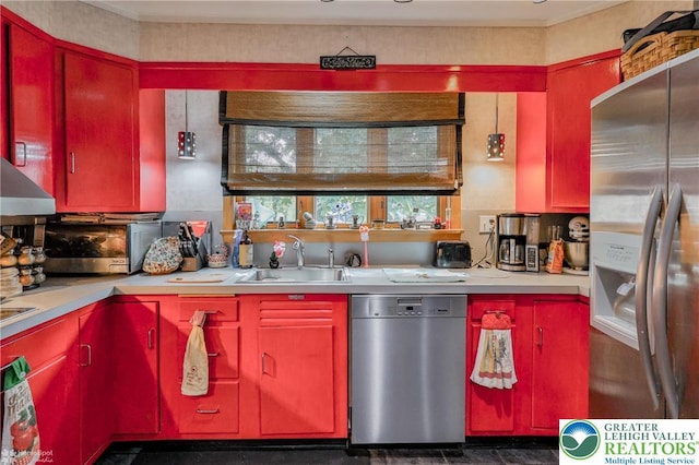 kitchen with stainless steel appliances, red cabinets, a sink, and light countertops