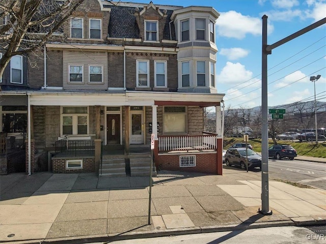 townhome / multi-family property featuring covered porch