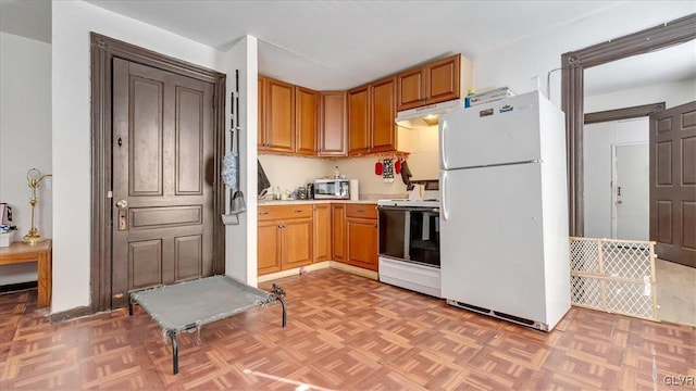 kitchen featuring white appliances, light countertops, and under cabinet range hood
