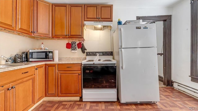kitchen featuring white appliances, under cabinet range hood, baseboard heating, brown cabinets, and a sink