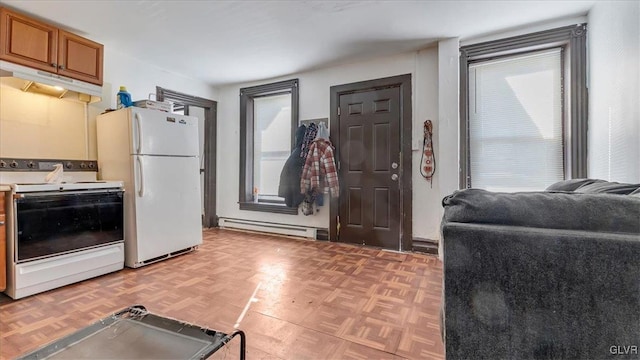 kitchen with white appliances, a baseboard radiator, under cabinet range hood, and plenty of natural light