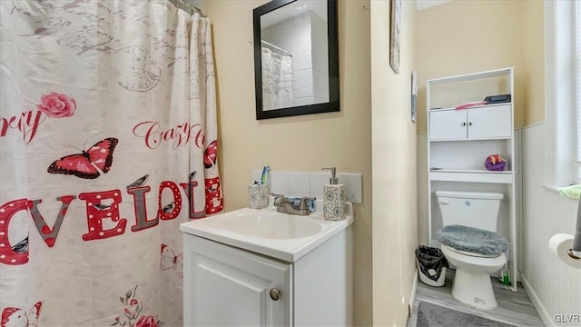 full bathroom with toilet, vanity, and wood finished floors