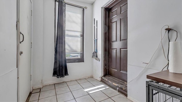 entryway with light tile patterned floors and baseboards
