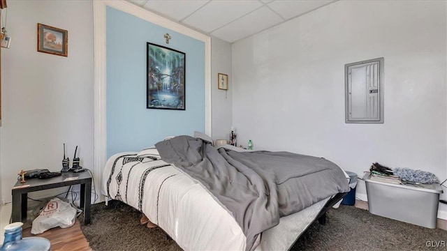 bedroom featuring electric panel and a drop ceiling