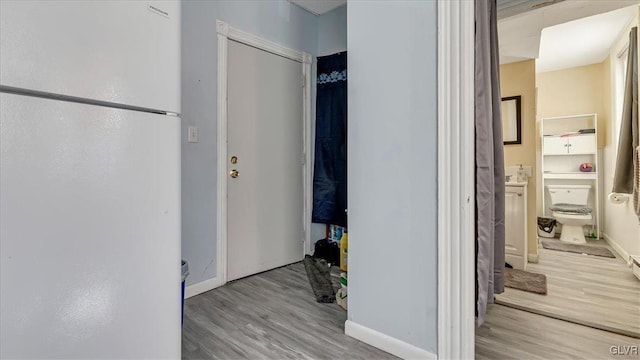 hallway featuring wood finished floors and baseboards