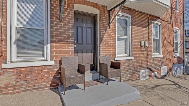 doorway to property with brick siding