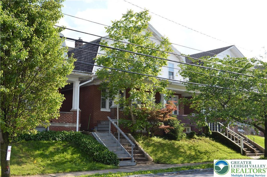 1338 Butler St, Easton, PA 18042 - view of property hidden behind natural elements with stairway, brick siding, and a chimney