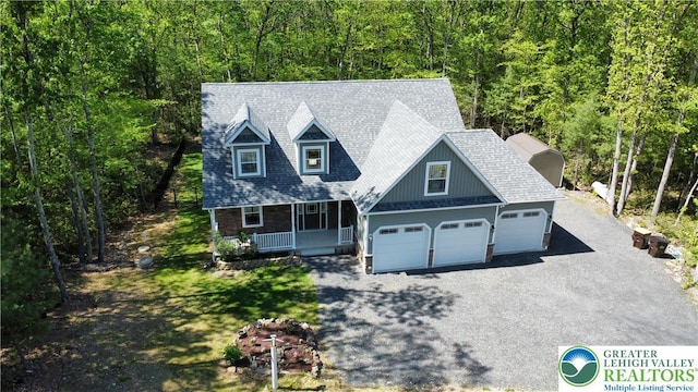 130 Corktree Rd, Polk Twp, PA 18058 - view of front of house with a porch, driveway, a view of trees, and an attached garage