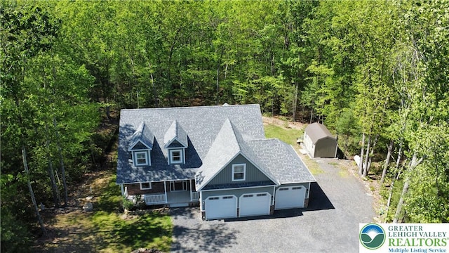 130 Corktree Rd, Polk Twp, PA 18058 - view of front of property with covered porch, asphalt driveway, an attached garage, and a view of trees