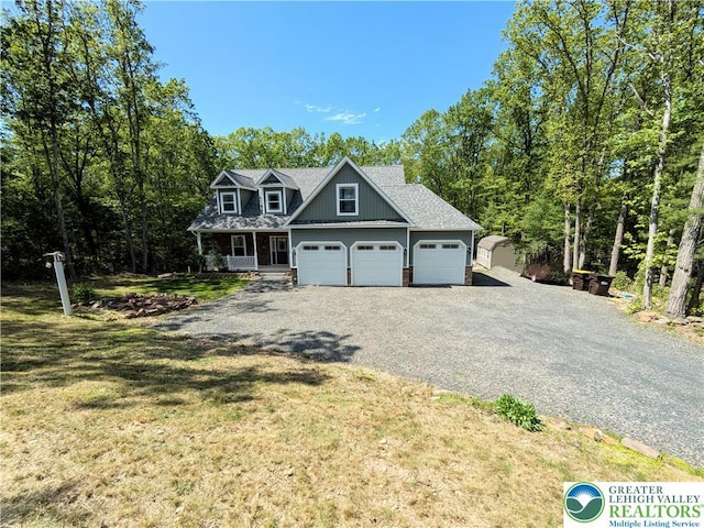 130 Corktree Rd, Polk Twp, PA 18058 - view of front of house with gravel driveway, a front yard, covered porch, an attached garage, and a shingled roof