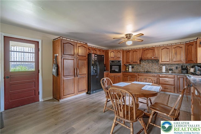 3082 Pricetown Rd, Pa, PA 19560 - kitchen with black appliances, premium range hood, brown cabinetry, a ceiling fan, and backsplash