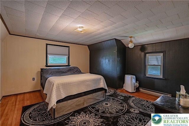 3082 Pricetown Rd, Pa, PA 19560 - bedroom with baseboard heating, wood finished floors, multiple windows, and wood walls