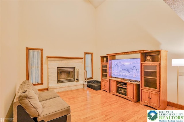 366 Winter Springs Rd, Bushkill Twp, PA 18064 - living room featuring high vaulted ceiling, light wood-style floors, a fireplace, and baseboards