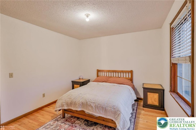 366 Winter Springs Rd, Bushkill Twp, PA 18064 - bedroom with light wood-style floors, a textured ceiling, and baseboards