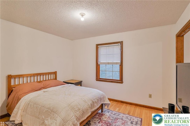 366 Winter Springs Rd, Bushkill Twp, PA 18064 - bedroom featuring light wood-type flooring, a textured ceiling, and baseboards
