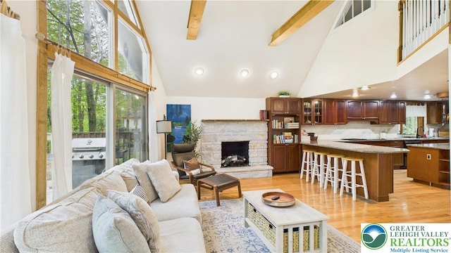 112 Moshannon Dr, Coolbaugh Twp, PA 18347 - living area featuring high vaulted ceiling, light wood-style flooring, beam ceiling, and a stone fireplace