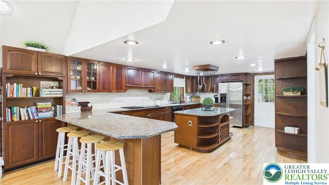 112 Moshannon Dr, Coolbaugh Twp, PA 18347 - kitchen with open shelves, black appliances, light wood-style flooring, a kitchen bar, and a peninsula