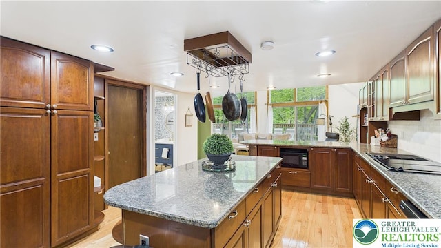 112 Moshannon Dr, Coolbaugh Twp, PA 18347 - kitchen with black appliances, light wood-style floors, light stone countertops, a peninsula, and a center island