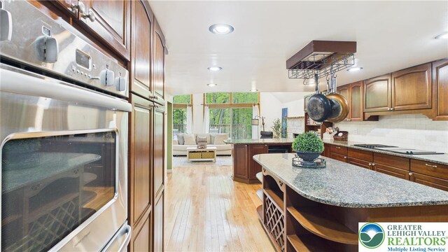 112 Moshannon Dr, Coolbaugh Twp, PA 18347 - kitchen featuring open shelves, oven, cooktop, light wood-style floors, and decorative backsplash
