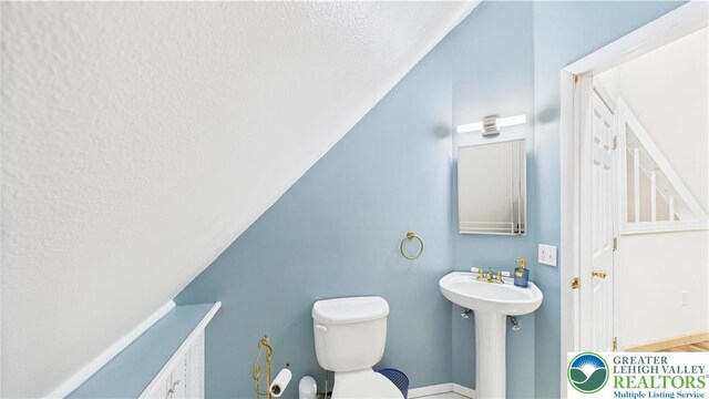 112 Moshannon Dr, Coolbaugh Twp, PA 18347 - bathroom featuring a textured ceiling, toilet, vaulted ceiling, and a sink