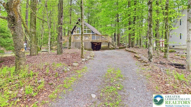 112 Moshannon Dr, Coolbaugh Twp, PA 18347 - view of front facade with a wooden deck, gravel driveway, a wooded view, and stairs