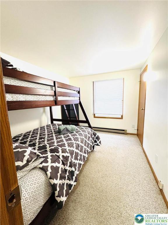 bedroom with a baseboard radiator, carpet floors, and baseboards