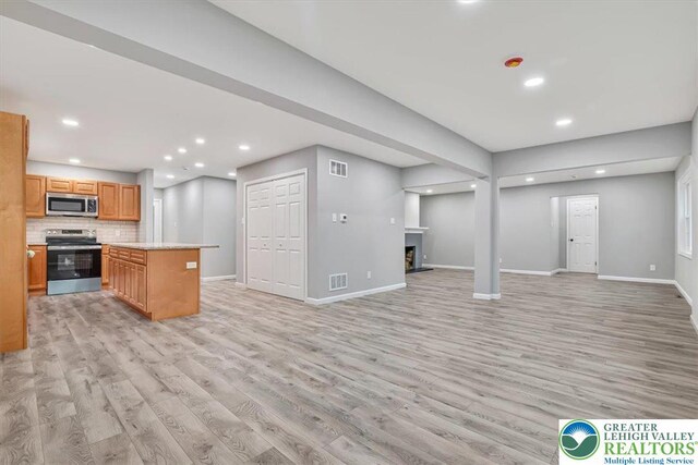 5653 Sullivan Trl, Plainfield Twp, PA 18064 - kitchen with stainless steel appliances, light wood-type flooring, open floor plan, baseboards, and light countertops