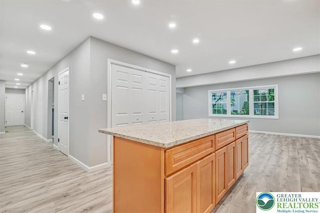 5653 Sullivan Trl, Plainfield Twp, PA 18064 - kitchen with light wood-type flooring, recessed lighting, light stone counters, a center island, and baseboards