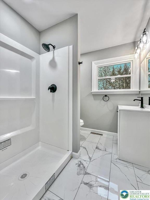5653 Sullivan Trl, Plainfield Twp, PA 18064 - full bathroom featuring marble look tiles, a shower stall, vanity, baseboards, and toilet
