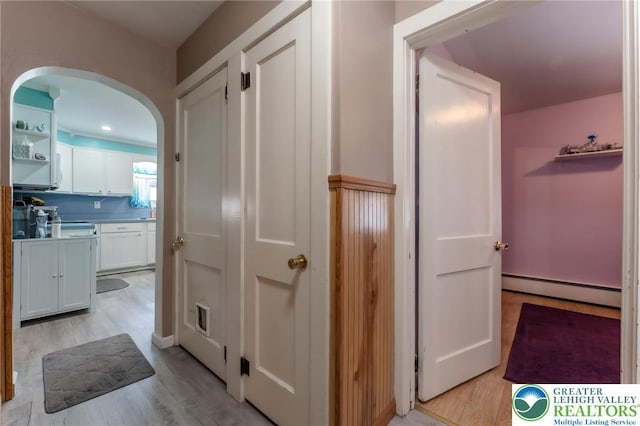 46 Jefferson St, Weatherly Borough, PA 18255 - hallway featuring baseboard heating, arched walkways, and light wood-style flooring