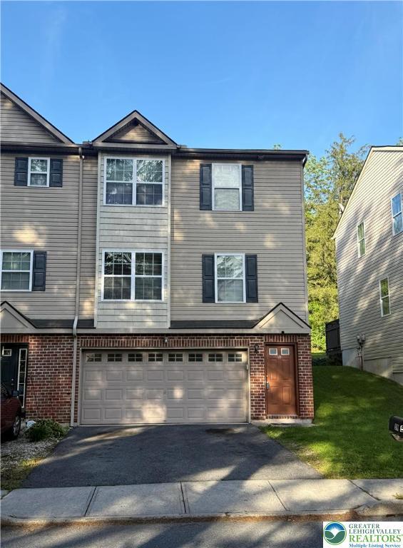 519 Lehigh Gap St, Walnutport Borough, PA 18088 - view of front of house featuring an attached garage, driveway, brick siding, and a front lawn