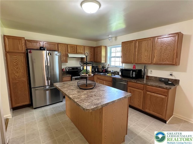 519 Lehigh Gap St, Walnutport Borough, PA 18088 - kitchen with stainless steel appliances, under cabinet range hood, brown cabinets, a kitchen island, and dark countertops
