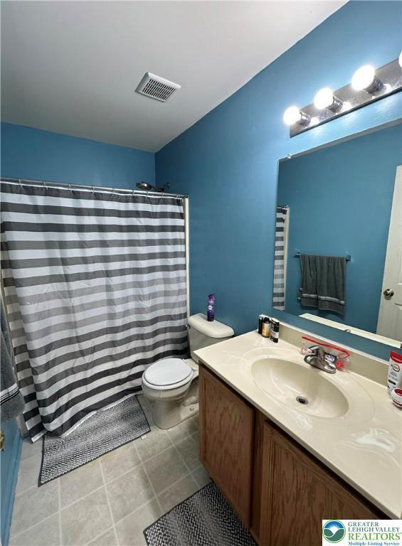 519 Lehigh Gap St, Walnutport Borough, PA 18088 - full bathroom with vanity, toilet, a shower with shower curtain, and tile patterned floors