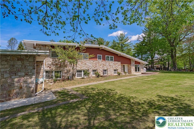 4205 Lehigh St, Whitehall Twp, PA 18052 - rear view of house featuring stone siding and a lawn