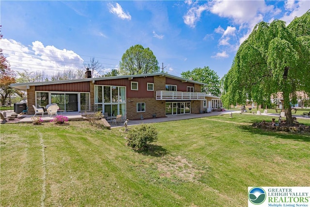 4205 Lehigh St, Whitehall Twp, PA 18052 - rear view of house featuring a patio, brick siding, a chimney, and a lawn