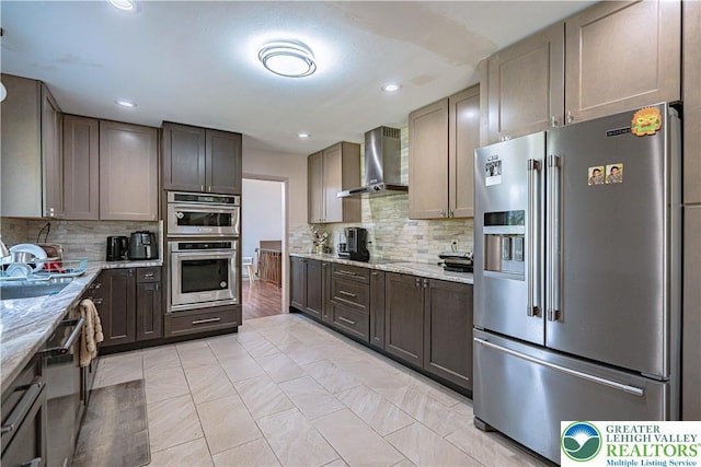 4205 Lehigh St, Whitehall Twp, PA 18052 - kitchen featuring appliances with stainless steel finishes, wall chimney range hood, backsplash, light stone counters, and recessed lighting