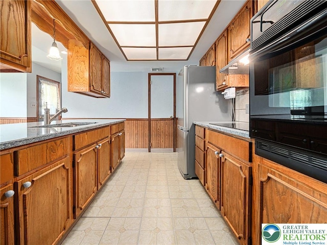 1218 Avocet Dr, Upper Macungie Twp, PA 18031 - kitchen with under cabinet range hood, a sink, brown cabinetry, and black appliances