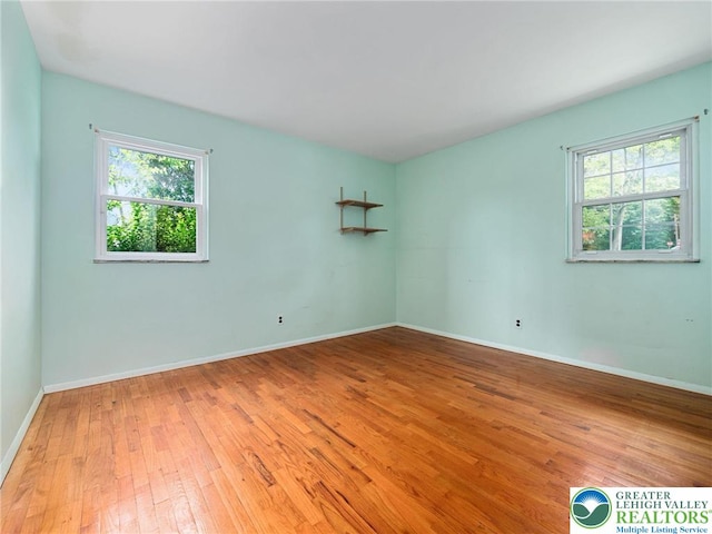 1218 Avocet Dr, Upper Macungie Twp, PA 18031 - empty room featuring healthy amount of natural light, hardwood / wood-style flooring, and baseboards