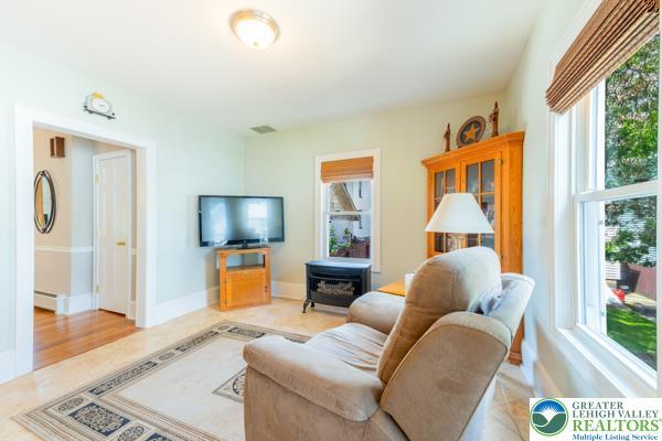 71 N 3rd St, Bangor Borough, PA 18013 - living area with plenty of natural light, a wood stove, a baseboard heating unit, and baseboards