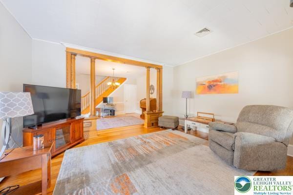 71 N 3rd St, Bangor Borough, PA 18013 - living room featuring wood finished floors, stairway, ornamental molding, a chandelier, and ornate columns