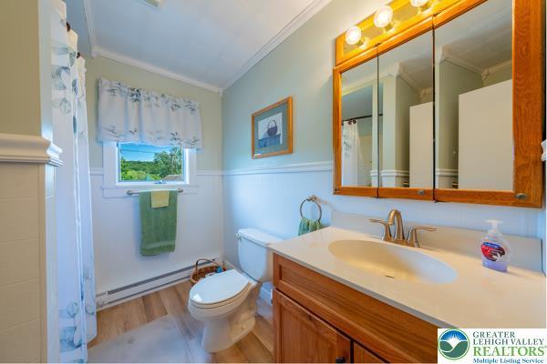 71 N 3rd St, Bangor Borough, PA 18013 - full bath with ornamental molding, wood finished floors, a baseboard radiator, vanity, and toilet