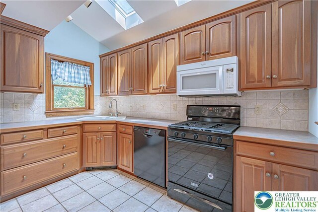 851 N Hoffert St, Fountain Hill Boro, PA 18015 - kitchen featuring black appliances, a skylight, a sink, vaulted ceiling, and light tile patterned floors