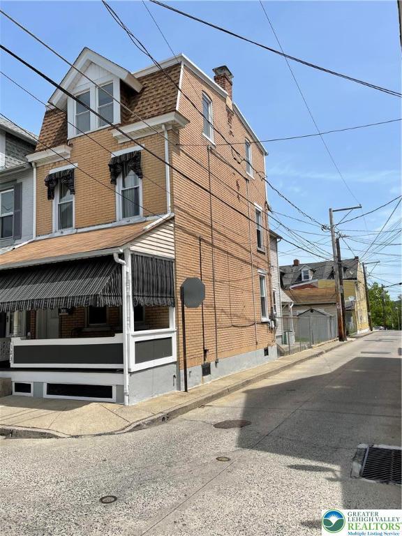 123 N Penn St, Allentown City, PA 18102 - view of home's exterior featuring brick siding and a chimney