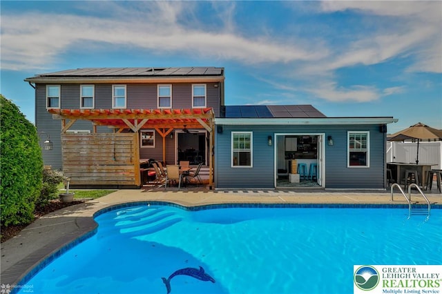 3940 Dewalt St, Bethlehem Twp, PA 18020 - rear view of house with a pergola, roof mounted solar panels, an outdoor pool, and a patio area