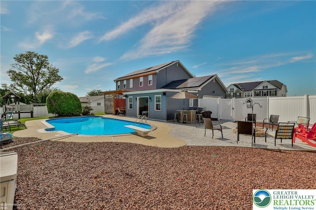 3940 Dewalt St, Bethlehem Twp, PA 18020 - view of pool with a fenced backyard, a diving board, a patio, an outbuilding, and a residential view