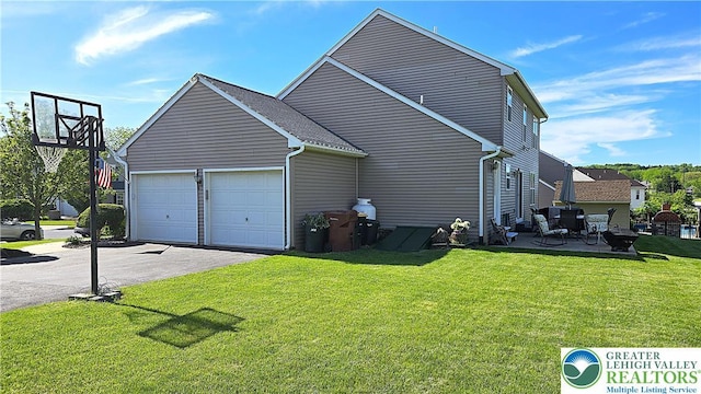 4125 Redbud Dr W, Whitehall Twp, PA 18052 - view of side of home featuring a garage, a lawn, and driveway