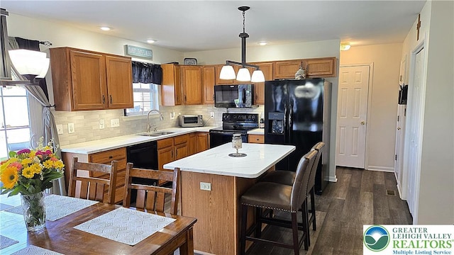 4125 Redbud Dr W, Whitehall Twp, PA 18052 - kitchen featuring black appliances, a sink, brown cabinets, dark wood finished floors, and backsplash